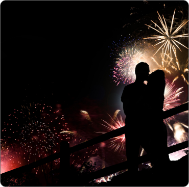 A couple is standing on the steps of fireworks.
